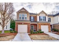 Charming townhome showcasing brick facade, manicured landscaping, and attached garages at 4224 Park South Station Blvd, Charlotte, NC 28210