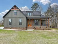 Charming gray two-story home with covered front porch and beautiful wood and brick accents at 1467 Centennial Dr, Rock Hill, SC 29732