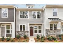 Charming townhome features stone accents, neutral siding and manicured landscaping creating a welcoming curb appeal at 2013 Near Point Rd # 20, Charlotte, NC 28208