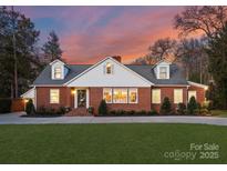 Charming brick home featuring lush lawn, manicured landscaping, and welcoming entrance at 2701 Sharon Rd, Charlotte, NC 28211