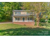 Charming two-story home featuring a welcoming front porch and complemented by lush, mature trees at 3430 Olde Oak Ln, Gastonia, NC 28056