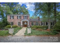 Charming brick home with a manicured lawn, stone walkway, and a covered front entrance at 419 Park Ridge Rd, Albemarle, NC 28001
