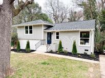 Charming single-story home featuring a combination of painted brick and gray siding with a well-manicured lawn at 5057 Murrayhill Rd, Charlotte, NC 28210