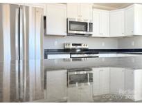 Modern kitchen featuring stainless steel appliances, white cabinets, and dark countertops at 553 Wateree St, Lancaster, SC 29720