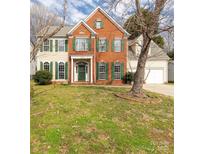 Charming two-story brick and siding home with green shutters, a well-manicured lawn, and an attached two-car garage at 9138 Babbitt Way, Charlotte, NC 28216