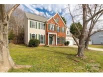 Charming two-story home featuring brick accents and green shutters, complemented by a well-maintained lawn at 9138 Babbitt Way, Charlotte, NC 28216