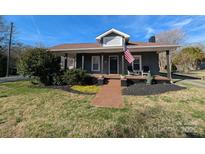 Charming home featuring inviting front porch, walkway, and beautiful landscaping at 101 Sunset Dr, Stanley, NC 28164