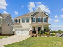 Charming two-story home with a well-manicured lawn and attached two-car garage on a sunny day at 1017 Cheviot Ct, Waxhaw, NC 28173