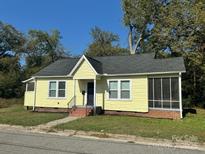 Charming yellow home featuring a screened in porch and classic architectural details at 103 Walker St, Chester, SC 29706