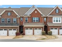 Charming brick townhome featuring attached garages and manicured landscaping under a bright blue sky at 113 Burlingame Ct # D, Mooresville, NC 28117