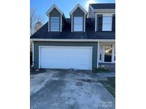 Olive green two story home featuring a spacious two car garage with a concrete driveway and front entrance at 12662 Woodside Falls Rd, Pineville, NC 28134