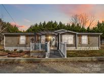 Charming home featuring gray siding, a welcoming porch with awning, and mature trees in the background at 1804 Tom Joye Rd, Clover, SC 29710