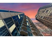 Dramatic view of a tall high rise building with balconies against a colorful sky at 210 N Church St # 1612, Charlotte, NC 28202