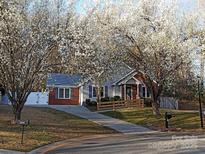 Charming single-story home featuring blooming trees, a brick accent wall, and a well-maintained front yard at 3008 Overlook Trl, Charlotte, NC 28212