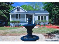 Charming home featuring a lovely front porch, tidy landscaping, and a decorative fountain at 315 Confederate St, Fort Mill, SC 29715