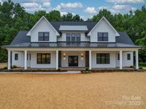 Stunning exterior of a two-story modern farmhouse with black trim windows and a welcoming front porch at 4024 Landsford Rd, Marshville, NC 28103
