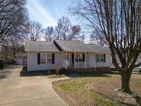 Charming single-story home with a welcoming front porch, gray siding, and well-maintained landscaping at 403 Easy St, Concord, NC 28027