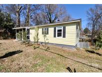 Charming single-story home featuring yellow siding, black shutters, and a screened in porch at 508 Bessemer City Rd, Gastonia, NC 28052