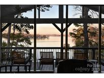 Inviting screened porch with water views, seating, and a glimpse of the serene lake at 547 Lake Shore Dr, Norwood, NC 28128