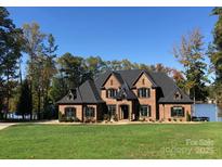 A beautiful brick home featuring multiple gables, black shutters, and a lush green lawn at 5628 Creole Rd, Clover, SC 29710
