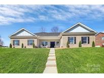 Charming brick home featuring black shutters, well-manicured lawn, and inviting front porch seating at 609 Rosemore Pl, Rock Hill, SC 29732