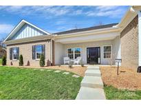 Charming brick home featuring a covered entryway, manicured lawn, and beautifully landscaped front yard at 609 Rosemore Pl, Rock Hill, SC 29732