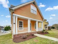 Charming home featuring a welcoming front porch with white pillars and beautiful yard at 7400 Gilead Rd, Huntersville, NC 28078