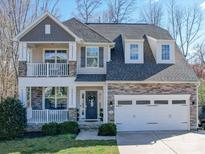 Charming two-story home with stone accents, balcony, well-manicured lawn, and a two-car garage at 7504 Canova Ln # 5, Charlotte, NC 28278