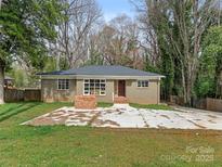 Charming single-story home with neutral brick exterior and a spacious front yard at 911 E Woodlawn Rd, Charlotte, NC 28209