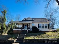 Charming single-story home featuring a covered porch, black shutters, and a well-maintained front yard at 1 Barrow St, Rock Hill, SC 29730