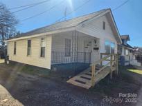 Charming single-Gathering home featuring vinyl siding, front porch, and a convenient handicap ramp at 105 Mcgill Nw Ave, Concord, NC 28025