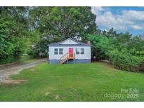 Charming single-story home with a well-maintained lawn and inviting front porch at 1304 S Main St, Mount Holly, NC 28120