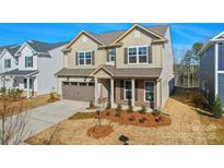 Charming two-story home showcasing neutral siding, a two-car garage, and manicured landscaping at 13729 Roderick Dr # 188, Huntersville, NC 28078