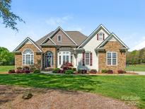 Charming home featuring stone accents, manicured lawn, and lush landscaping at 16160 Hopewell Church Rd, Midland, NC 28107