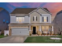 Charming two-story home with a well-manicured lawn, stone accents and a cozy front porch with rocking chairs at 187 Tetcott St, Mooresville, NC 28115