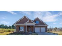 Charming single-story home boasts a manicured lawn, covered porch, and two-car garage at 19031 Brandon James Dr, Cornelius, NC 28031