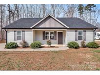 Charming single-story home featuring gray siding, a dark roof, and well-maintained landscaping at 1980 Stirewalt Rd, China Grove, NC 28023