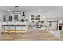 Bright, open kitchen with island seating, modern appliances, and a cozy seating area by the windows at 301 Dollar Cir, Charlotte, NC 28270