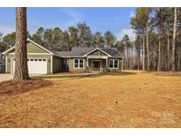 Charming craftsman style home boasts a two-car garage and a sprawling front lawn with mature trees at 318 Lewis Ferry Rd, Statesville, NC 28677