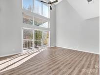 Bright living room featuring a large window, sliding glass door, and wood flooring at 3655 Warp St, Charlotte, NC 28205