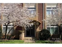 Charming brick building entrance with blooming trees, and planters flanking the walkway at 404 N Laurel Ave # 28, Charlotte, NC 28204