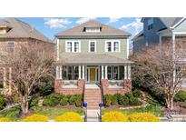 Charming two-story home with a welcoming front porch, manicured landscaping, and a brick stairway leading to the entrance at 415 Vintage Hill Ln, Huntersville, NC 28078