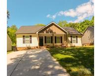 Charming single-story home featuring a concrete driveway, well-manicured lawn, and inviting curb appeal at 648 E Ketchie St, China Grove, NC 28023