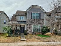 Charming two-story home featuring stone accents, gray siding and meticulously maintained landscaping at 7015 Walnut Branch Ln, Charlotte, NC 28277