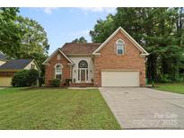 Charming brick home featuring an attached two-car garage and well-manicured lawn at 8731 Sheltonham Way, Charlotte, NC 28216