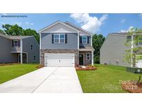 Charming two-story home featuring a stone-accented facade, attached two-car garage, and manicured lawn at 1014 Hostler Ln, York, SC 29745