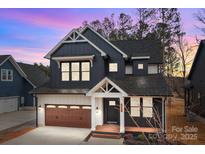 Beautiful exterior elevation with dark siding, wood garage door, and tasteful architectural details at 119 Mills Garden Rd, Statesville, NC 28625