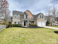 Charming two-story home featuring a manicured lawn and a two-car garage at 1580 Duckhorn Nw St, Concord, NC 28027