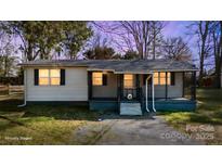 Charming single-story home featuring a cozy front porch and well-maintained landscaping at 20016 Walter Henderson Rd, Cornelius, NC 28031