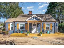 Charming blue house with a covered porch and light wood shutters creates an inviting curb appeal at 2137 Highland St, Charlotte, NC 28208